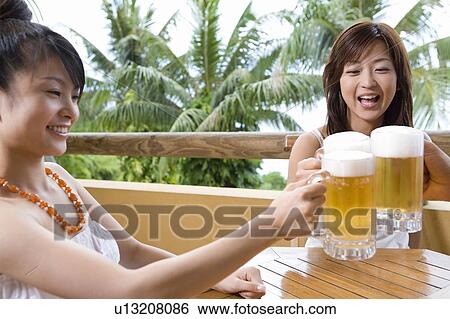 Stock Photograph - Young people toasting with beer, Saipan. Fotosearch