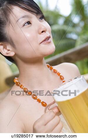 Stock Photo - Young woman holding a beer, Saipan. Fotosearch