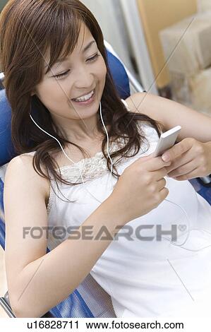 Young woman listening to music, Saipan View Large Photo Image Stock Image - Young woman listening to music, Saipan. Fotosearch