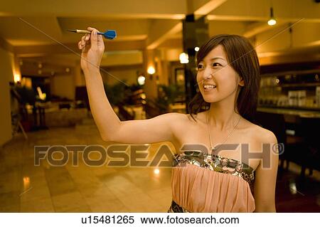 Stock Photography - Young woman playing darts, Saipan. Fotosearch