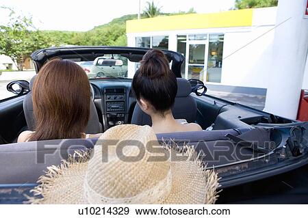 Stock Photo - Young women sitting in the car in gas station, Saipan, USA . Fotosearch