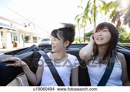 Picture - Young women smiling in the car, Saipan, USA . Fotosearch