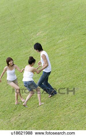 Stock Photo - Young people smiling and playing on lawn, Saipan, USA . Fotosearch