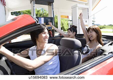 Stock Image - Young people in gas station, smiling, Saipan, USA . Fotosearch