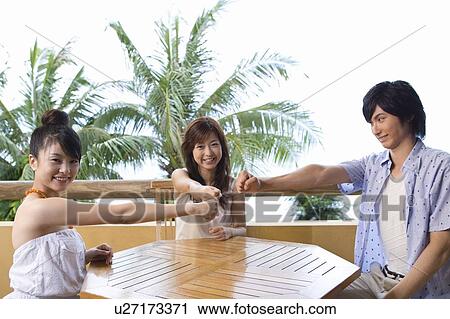 Stock Image - Young people playing rock paper scissors, Siapan. Fotosearch