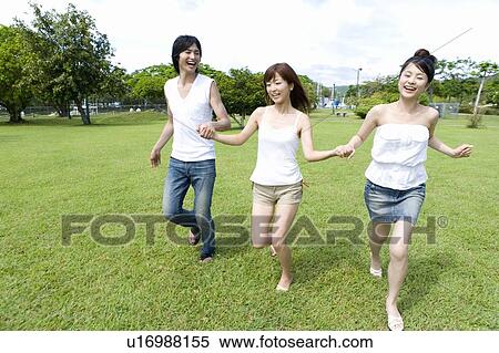 Young people smiling and running on lawn, hand in hand, Saipan, USA View Large Photo Image Stock Photography - Young people smiling and running on lawn, hand in hand, Saipan, USA . Fotosearch
