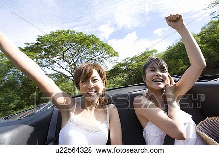Young women smiling in the car, raising arm, Saipan, USA View Large Photo Image Stock Photo - Young women smiling in the car, raising arm, Saipan, USA . Fotosearch