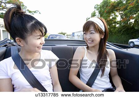 Stock Photography - Young women smiling in the car, Saipan, USA . Fotosearch