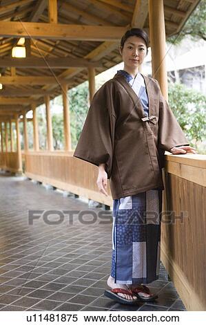 Stock Photography - Portrait of a woman in Yukata at the corridor of the Japanese inn, front view, Japan. Fotosearch