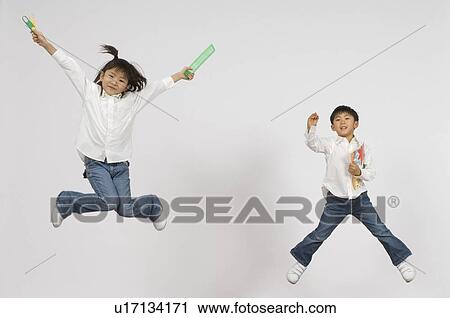 Stock Image - Boy and Girl holding stationery. Fotosearch