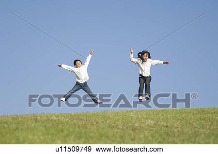 Boy and Girl jumping on grass View Large Photo Image Stock Photo - Boy and Girl jumping on grass. Fotosearch