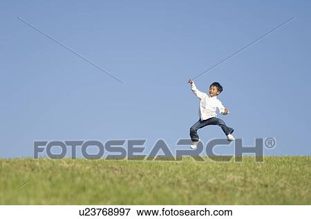 Boy jumping on grass View Large Photo Image Stock Photo - Boy jumping on grass. Fotosearch