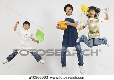 Stock Image - Family holding cleaning tool. Fotosearch