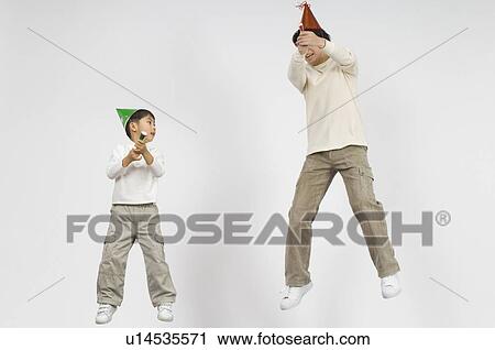 Stock Image - Father and boy holding firecracker. Fotosearch
