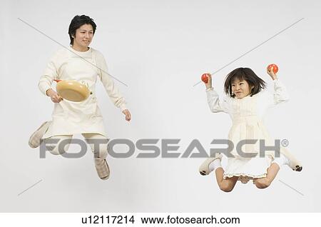 Picture - Girl holding apple and father holding pan. Fotosearch