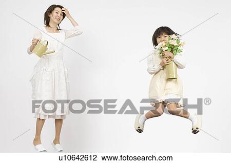 Girl holding flower and mother holding watering can View Large Photo Image Stock Image - Girl holding flower and mother holding watering can. Fotosearch