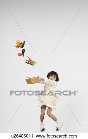 Girl holding vegetable in basket View Large Photo Image Stock Image - Girl holding vegetable in basket. Fotosearch