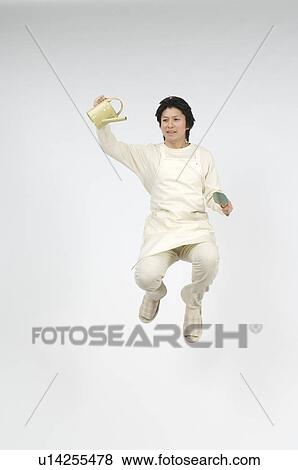 Stock Photo - Man holding shovel and watering can. Fotosearch