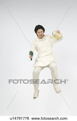 Stock Photograph - Man holding shovel and watering can. Fotosearch