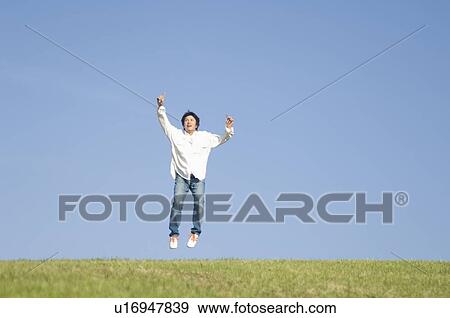 Stock Photo - Man jumping on grass. Fotosearch