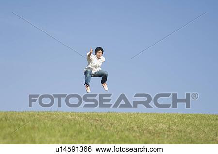 Stock Photograph - Man jumping on grass. Fotosearch