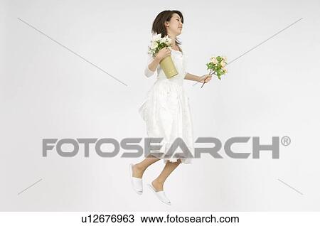 Young woman holding flower View Large Photo Image Stock Image - Young woman holding flower. Fotosearch