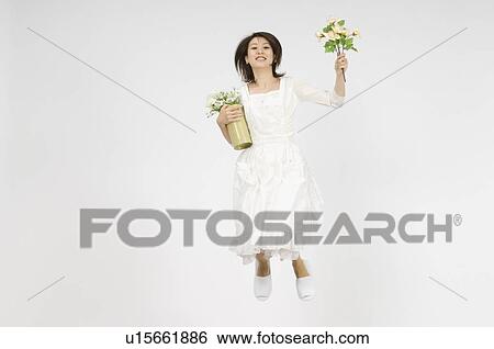 Stock Photograph - Young woman holding flower. Fotosearch