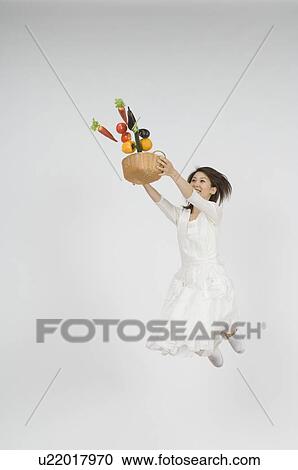 Young woman holding vegetable in basket View Large Photo Image Stock Image - Young woman holding vegetable in basket. Fotosearch