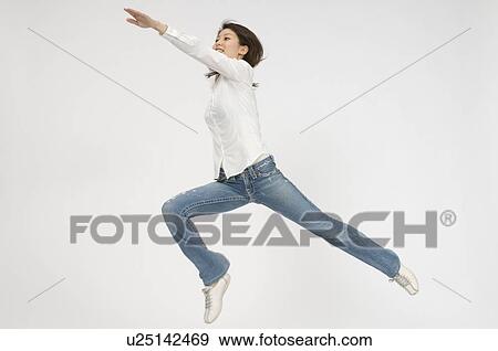 Stock Photo - Young woman jumping. Fotosearch
