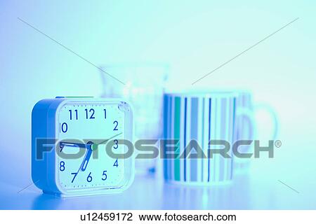 Stock Image - Alarm clock and mugs. Fotosearch