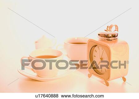 Alarm clock and tea cups View Large Photo Image Stock Photo - Alarm clock and tea cups. Fotosearch