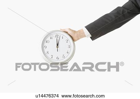 Picture - Arm of businessman holding clock. Fotosearch