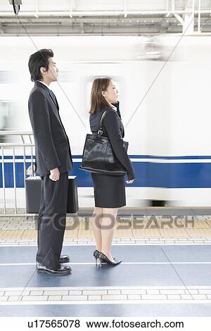 Stock Photo - Business people standing at station. Fotosearch