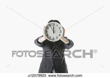 Stock Photography - Businessman holding clock. Fotosearch