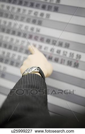 Stock Photo - Businessman pointing at timetable. Fotosearch