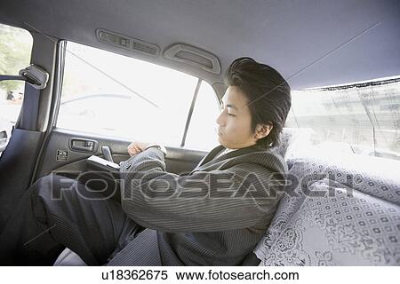 Stock Photography - Businessman sitting in Taxi. Fotosearch