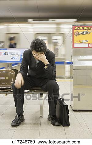 Businessman sitting on bench at platform View Large Photo Image Stock Photo - Businessman sitting on bench at platform. Fotosearch