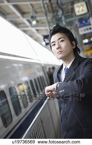 Stock Photo - Businessman standing at station. Fotosearch