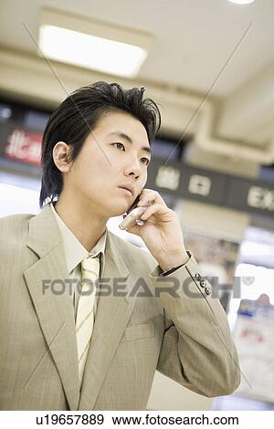 Stock Photo - Businessman talking with cellular phone. Fotosearch
