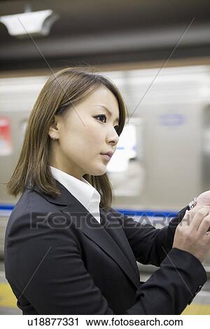 Businesswoman looking at wristwatch View Large Photo Image Stock Image - Businesswoman looking at wristwatch. Fotosearch