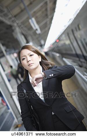 Stock Image - Businesswoman standing at station. Fotosearch