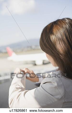 Stock Image - Businesswoman waiting at airport. Fotosearch