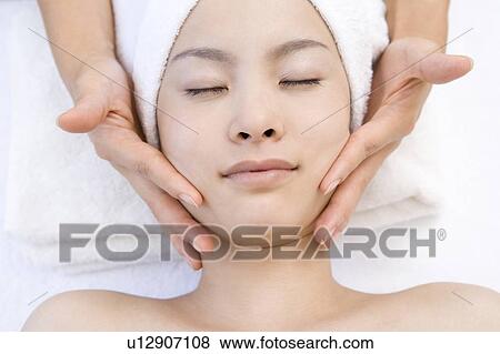 Stock Photo - Young woman getting a facial massage, Saipan. Fotosearch