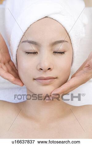 Stock Photo - Young woman getting a facial massage, Saipan. Fotosearch