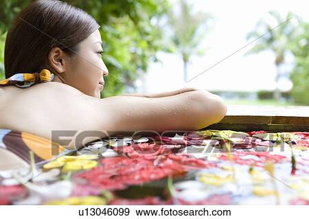 Young woman in a bath full of flowers, Saipan, Rear View View Large Photo Image Stock Photo - Young woman in a bath full of flowers, Saipan, Rear View. Fotosearch