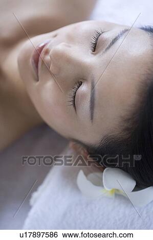 Stock Photograph - Young woman lying on a massage table . Fotosearch