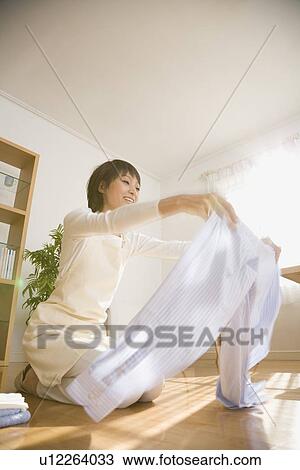 Housewife folding shirt View Large Photo Image Stock Image - Housewife folding shirt. Fotosearch