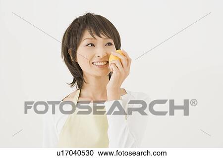 Stock Image - Housewife holding lemon. Fotosearch