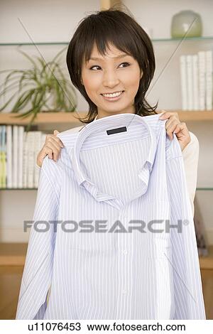 Housewife holding shirt View Large Photo Image Stock Image - Housewife holding shirt. Fotosearch