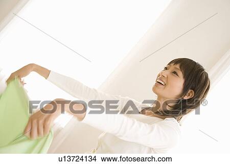 Picture - Housewife spreading table cloth. Fotosearch